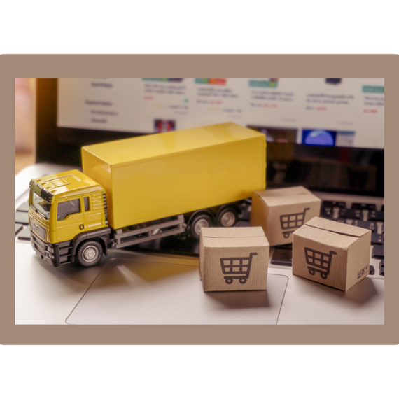 Toy lorry with boxes in front of an ecommerce website on laptop